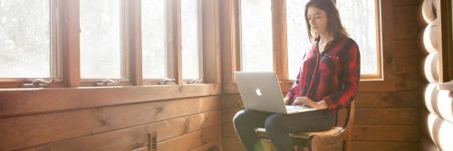 woman sits alone busy working on apple macbook