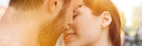 couple about to kiss in sunny sky