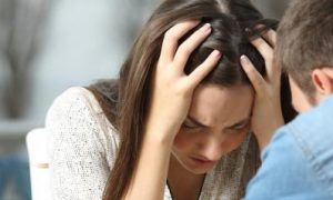 couple has trouble while woman sitting scratching hair angrily