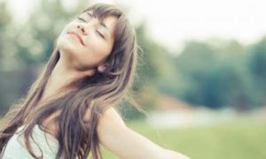woman eyes closed raises hands gratitude life on field