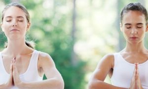 two young women wearing couple t shirt focuses on meditation