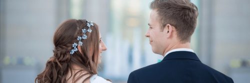 married couple stands looking at each other smiling