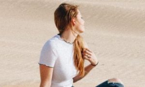 woman sits on desert enjoying weather
