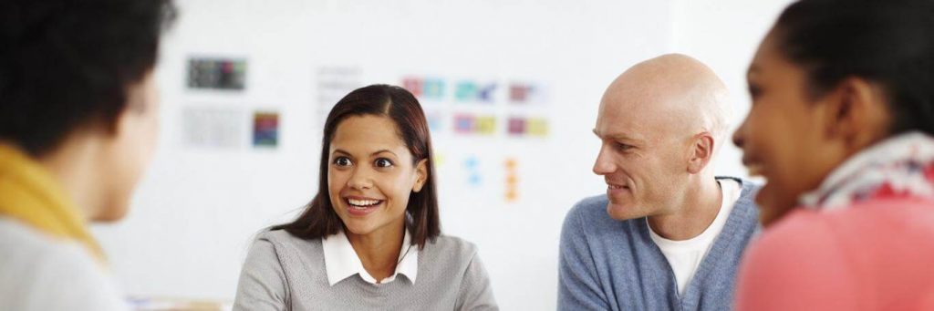 group of people happily communicates discusses in co working room
