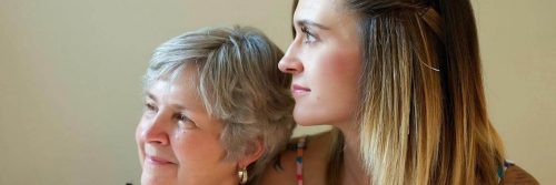 mother sits with daughter happily smiling