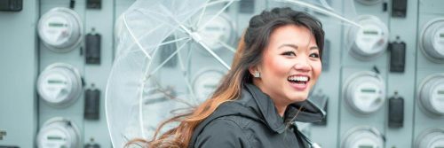 woman carries umbrella happily smiles