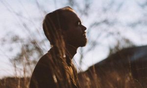woman stands on field worrying thinking
