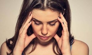 woman hands on face look downward distressed