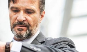 businessman checking watch as of being late