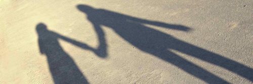 two people shadow holding hands on street