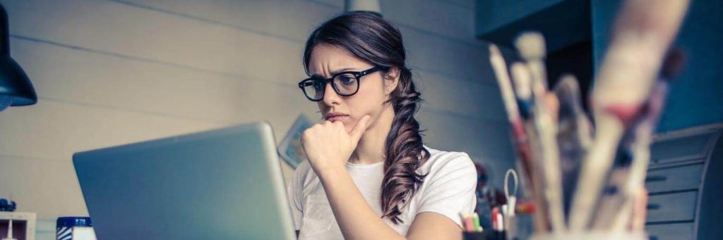 woman sits in office focusing on work laptop