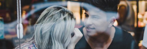 couple sits in coffee shop looking at talking to each other
