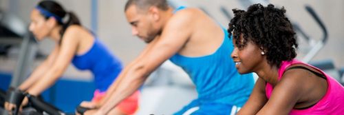 group of mixed gender training energetically on biking machine