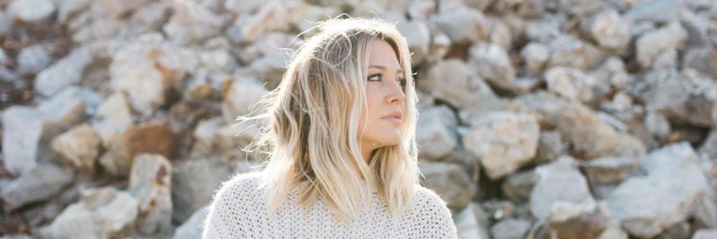 woman stands on stones looking