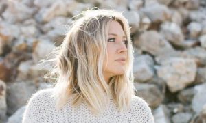 woman stands on stones looking