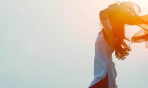 woman stands gratitude life in sunny sky