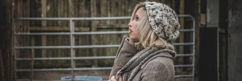 woman with worrying face stands beside fence