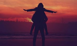 woman shadow raising hand in red sunset sky