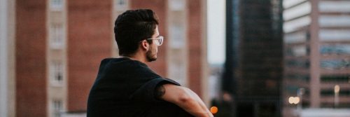 man sitting alone in city thinking