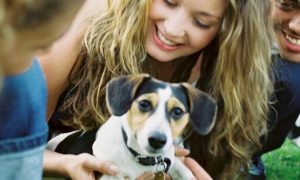 two women one man look smile at puppy
