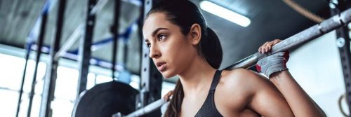 woman carries barbell working out exercising in gym