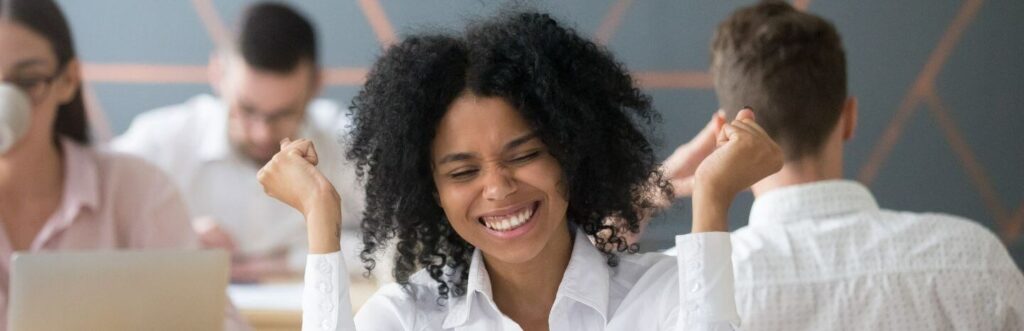 woman of colour celebrating success professional white shirt