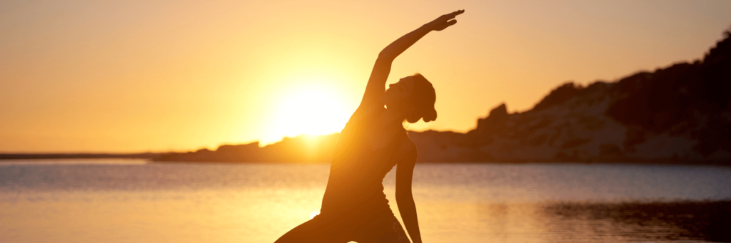 Women in golden sunrise doing yoga