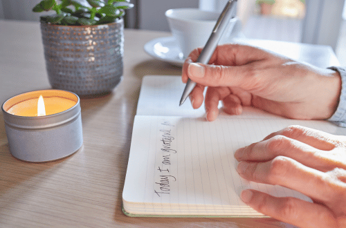 person writing in a gratitude journal practicing mind Mastery