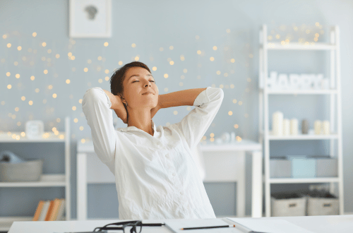 woman sitting at her desk mindfully breathing practicing Daily Micro Habits