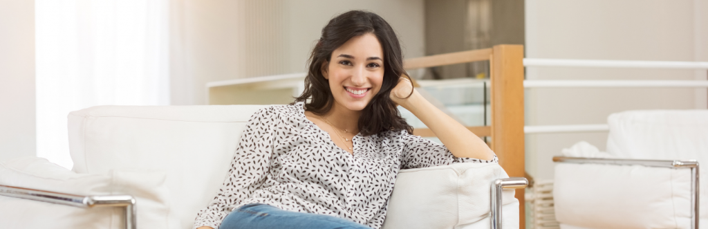 young woman with happy face smiles poses on white coach